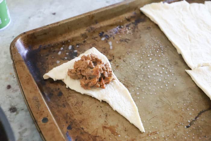 adding beef to the crescent roll