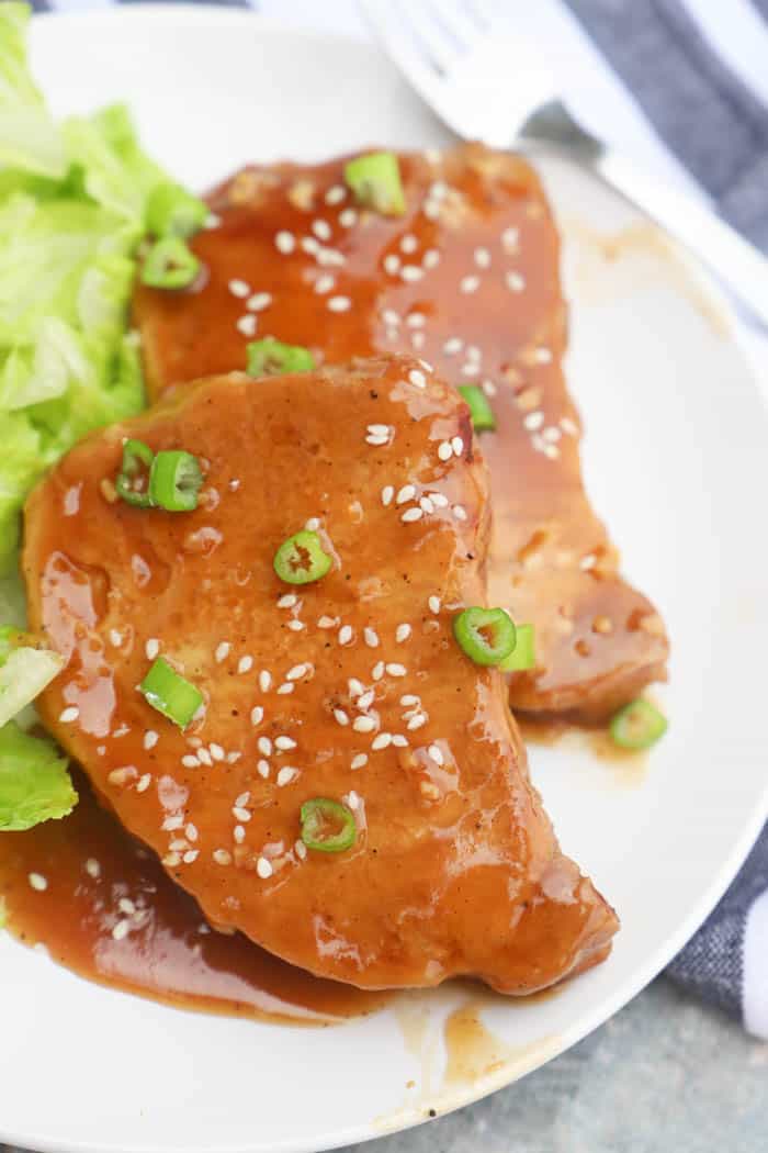 Teriyaki Pork Chops on a plate with sesame seeds and green onions