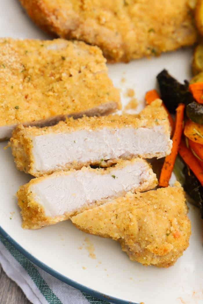 Parmesan Crusted Pork Chops cut and served on a plate