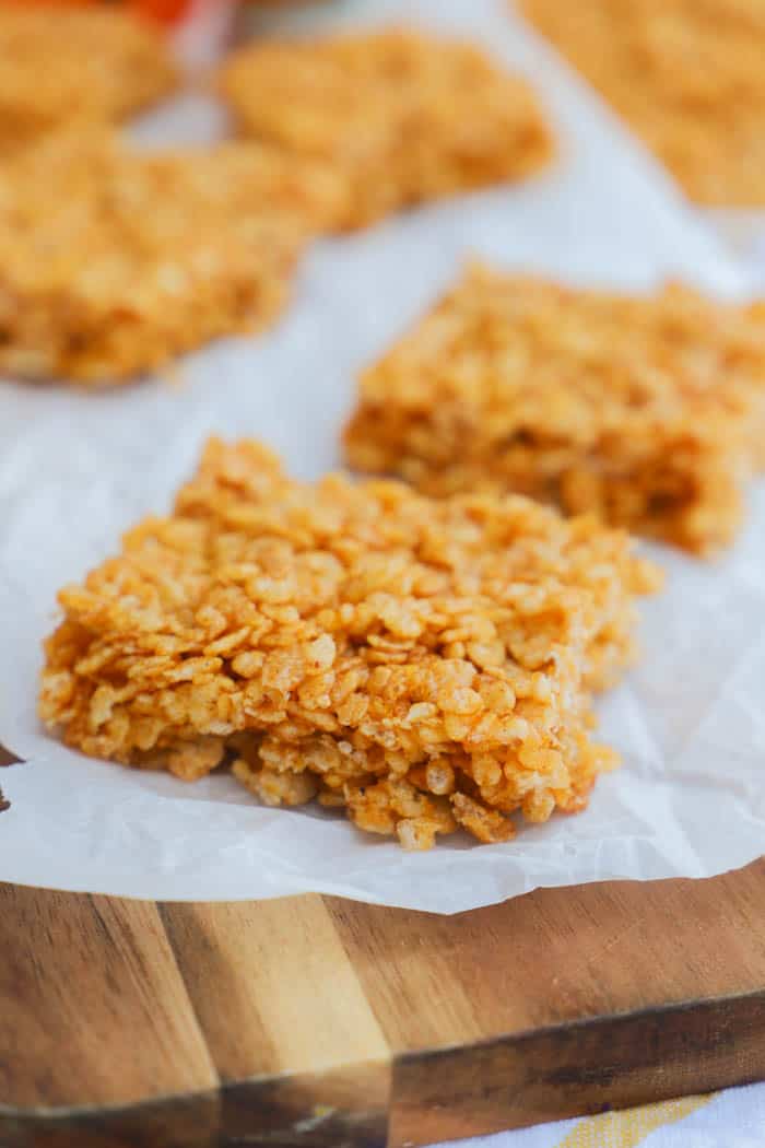 Pumpkin Spice Rice Krispies Treats on a brown cutting board