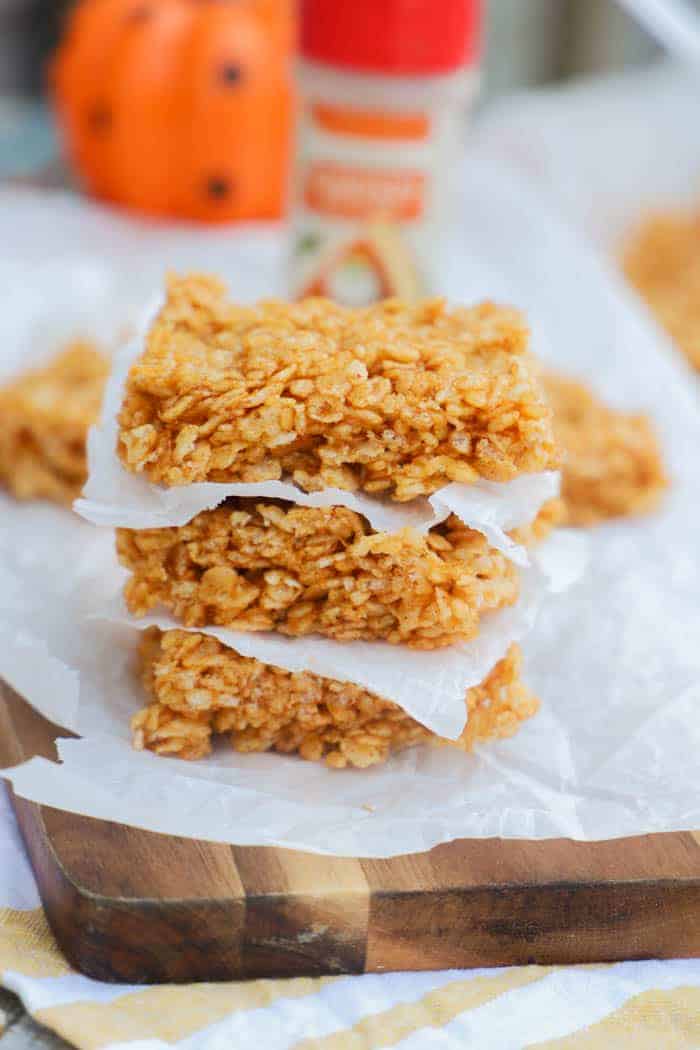 Pumpkin Spice Rice Krispies Treats stacked on a cutting board