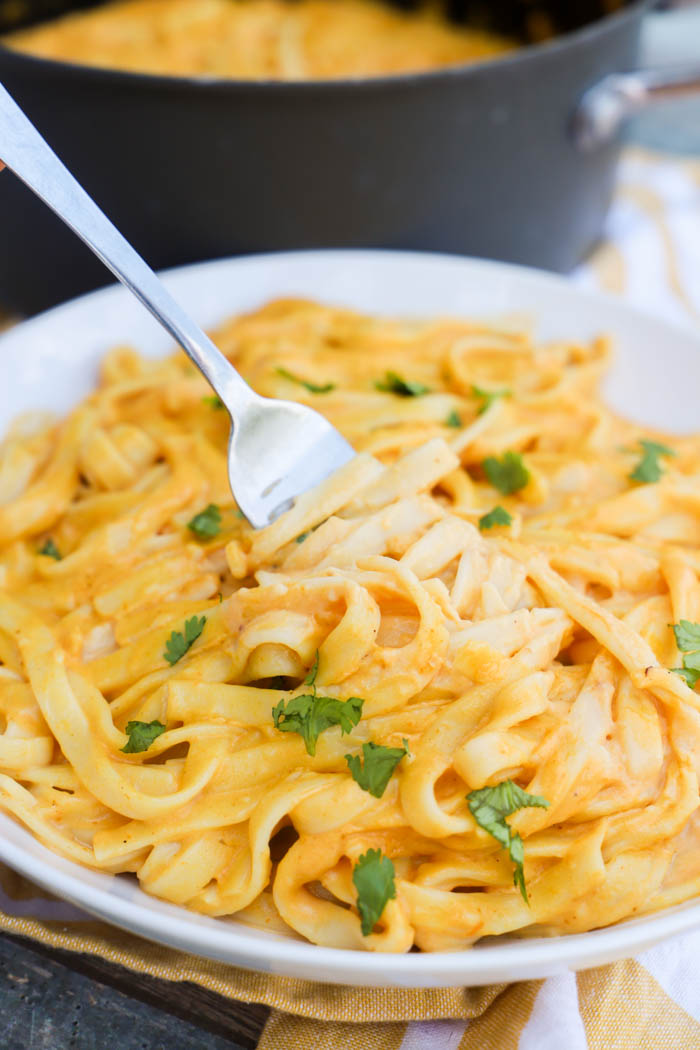 pumpkin pasta in a bowl with a fork