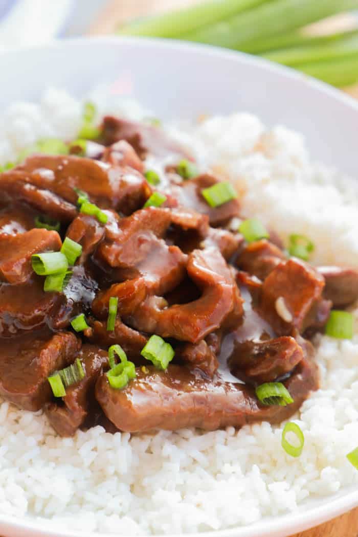 Slow Cooker Mongolian Beef in a white bowl on rice