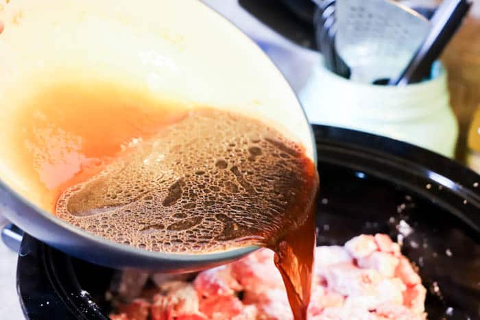 adding sauce to the slow cooker