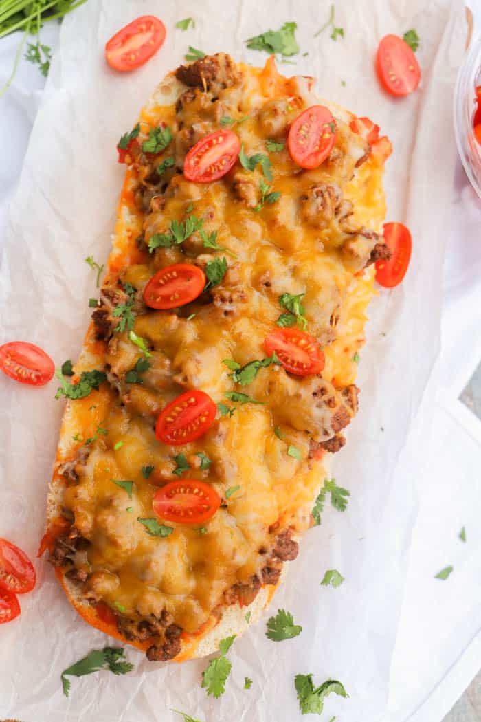 Taco French Bread Pizza topped with tomatoes and cilantro