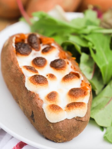 Twice Baked Sweet Potato on a white plate with salad