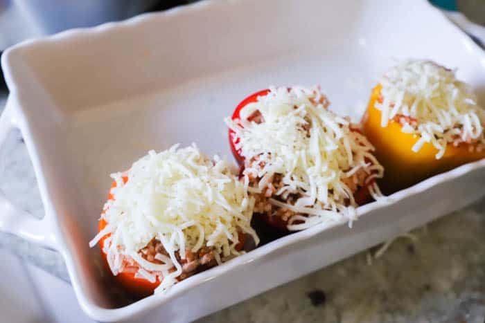 adding stuffed peppers to a casserole dish