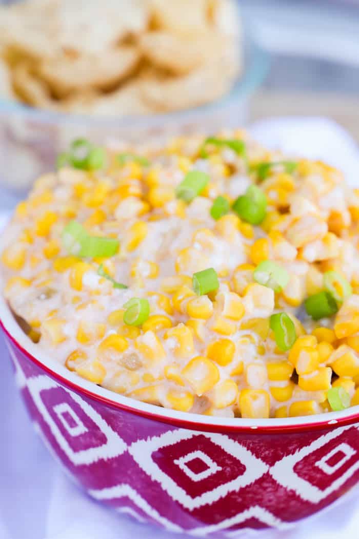 Hot Corn Dip in a red bowl with chips