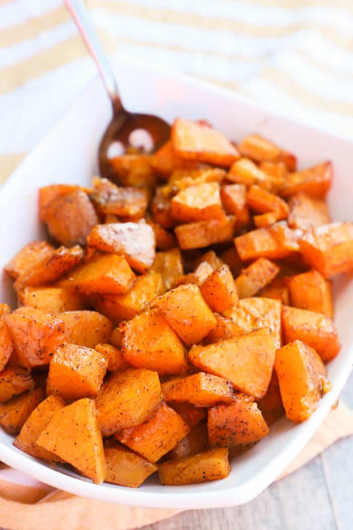 Roasted Butternut Squash in a white bowl with a spoon.