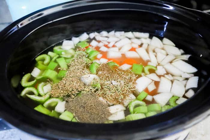 adding seasoning to the Slow Cooker Chicken Noodle Soup