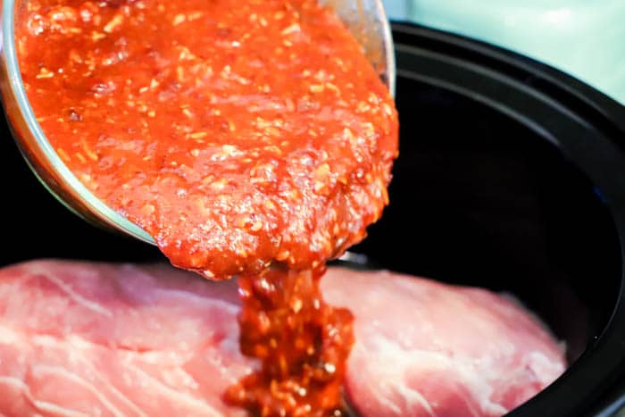 pouring sauce over the pork loin