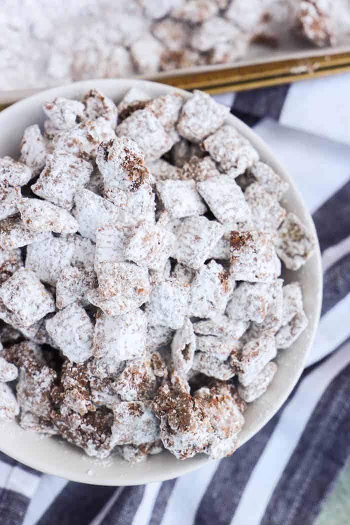 Muddy Buddies in a white bowl and black napkin