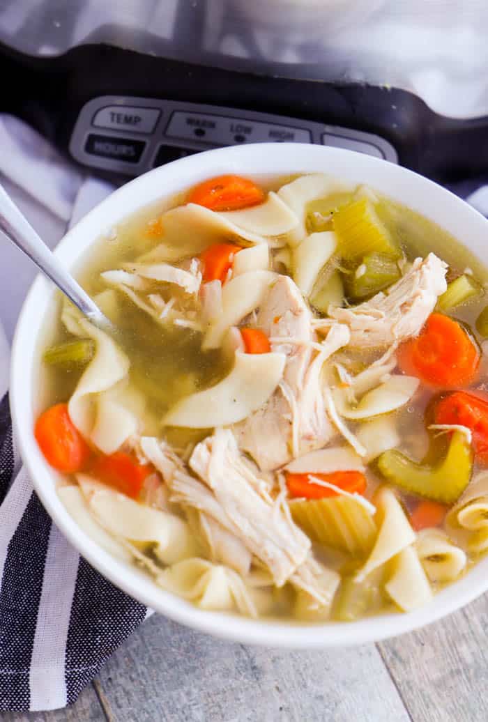 Slow Cooker Chicken Noodle Soupm in awhite bowl with a spoon