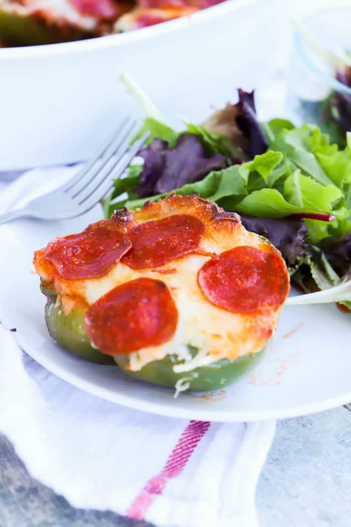 Pizza Stuffed Peppers on a white plate with salad