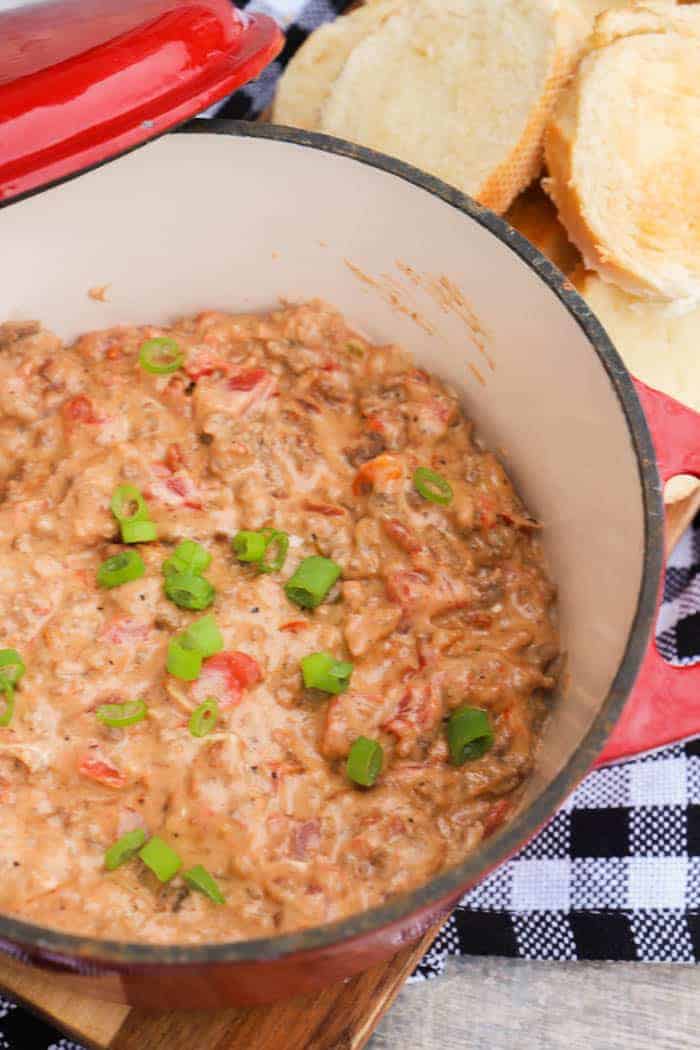 Bacon Cheeseburger Dip in a red pan topped with green onions