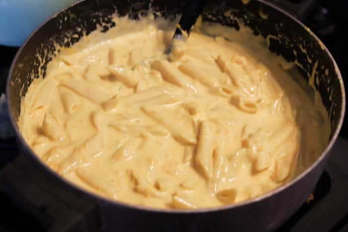 Cheesy Penne Bake in a sauce pan melting cheese