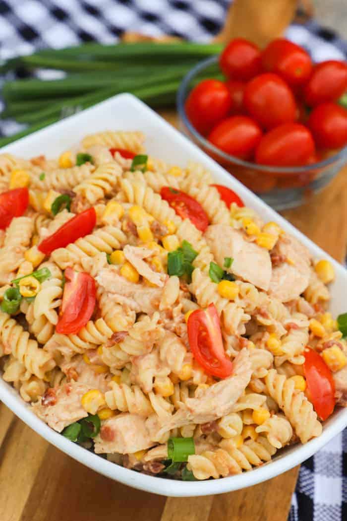 BBQ Chicken Pasta Salad in a white bowl with side of tomatoes