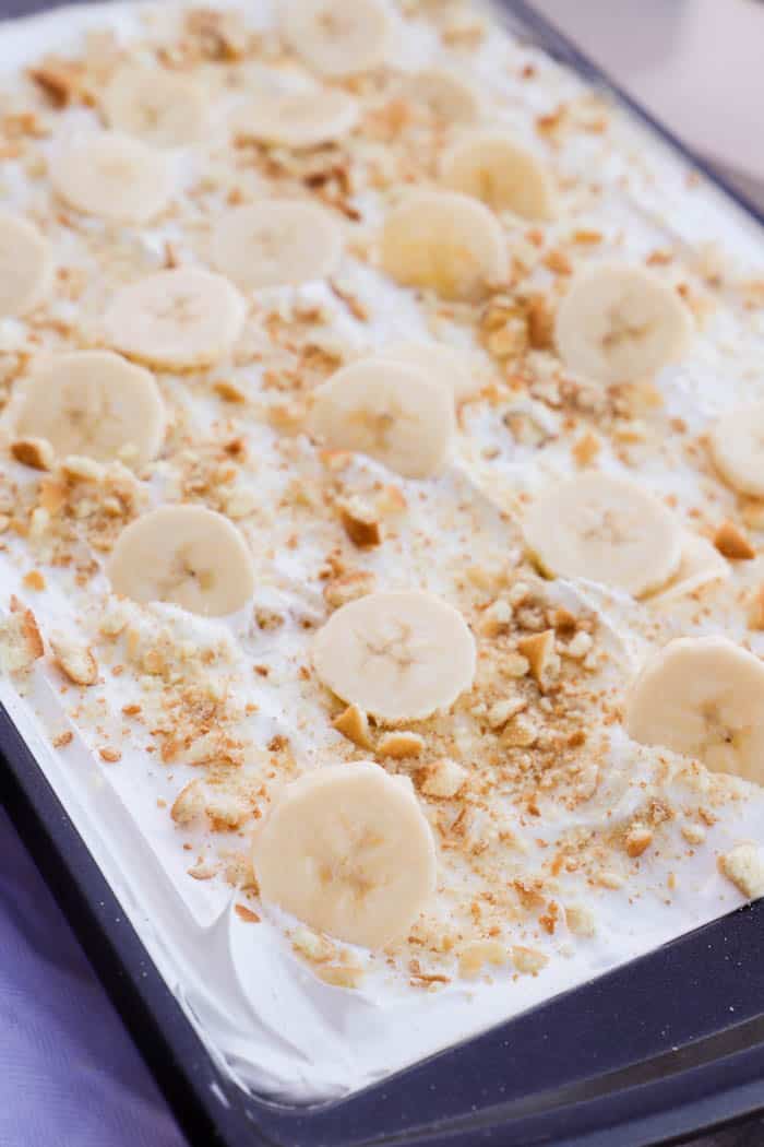 Banana Pudding Poke Cake in the pan topped with fresh bananas