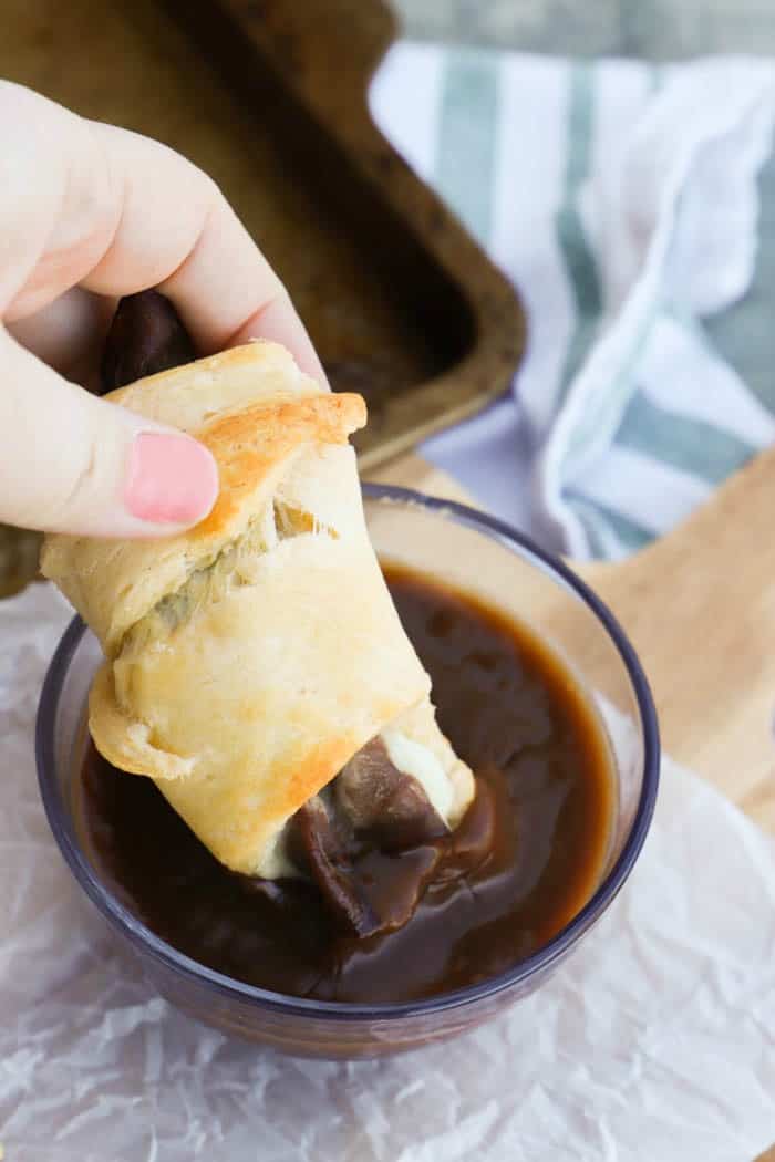 dipping French Dip Crescents in sauce