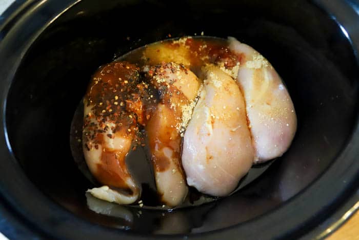 adding ingredients into the slow cooker