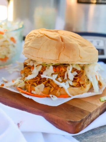 Slow Cooker Shredded Asian Chicken Sandwich on a wooden serving dish