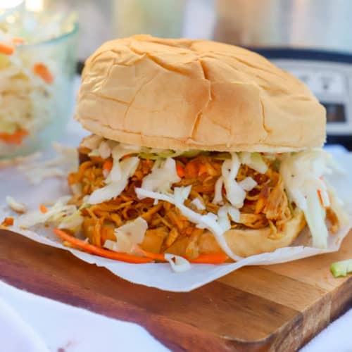 Slow Cooker Shredded Asian Chicken Sandwich on a wooden serving dish