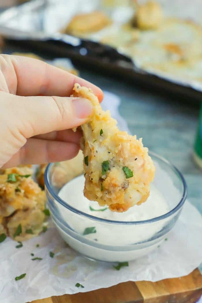 dipping Parmesan Garlic Wings in ranch dressing