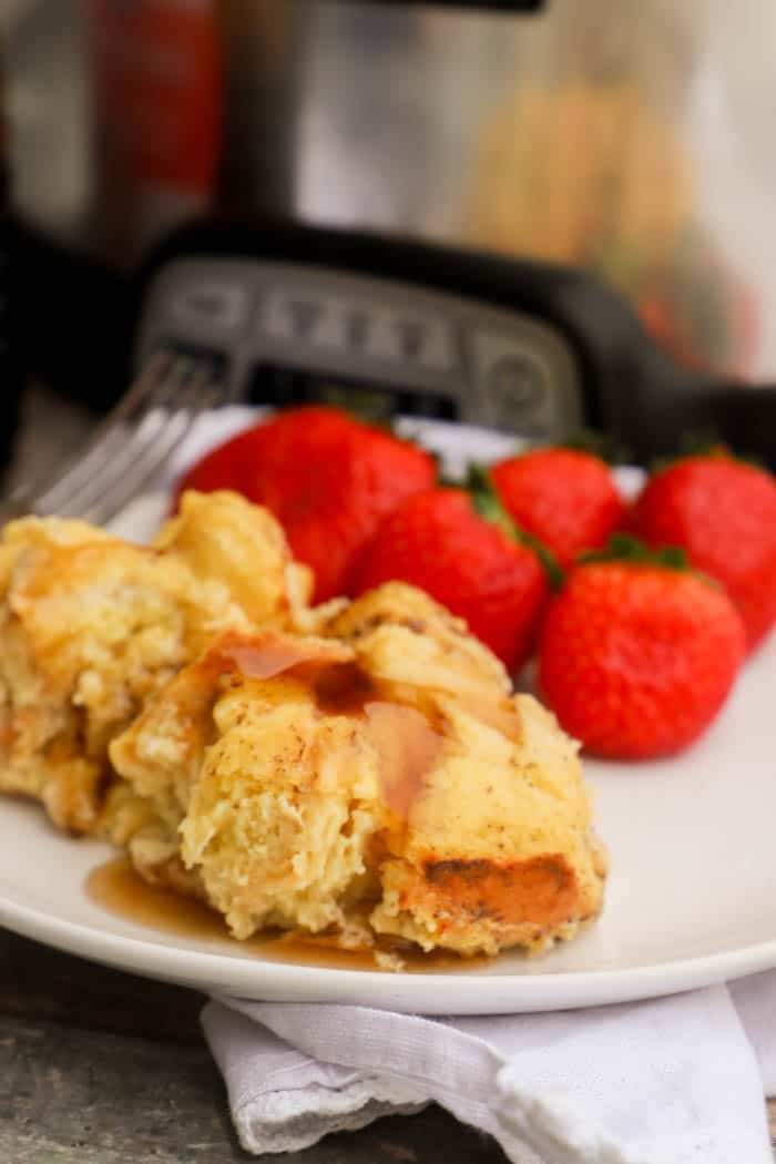 Slow Cooker French Toast Casserole on a white plate with strawberries