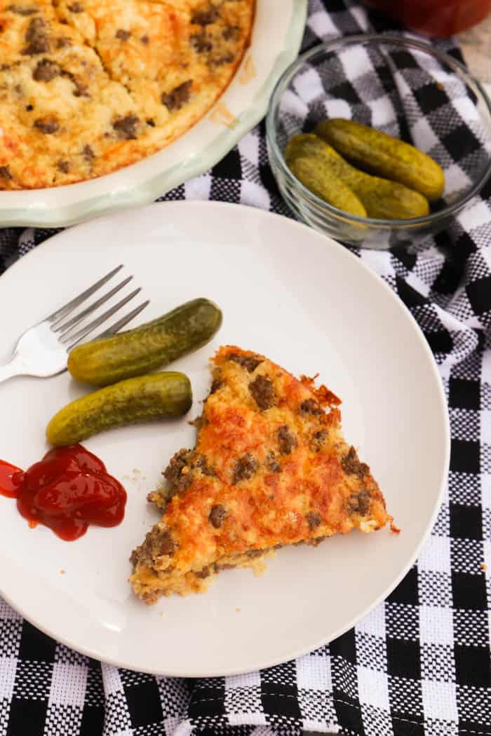 Bacon Cheeseburger Pie on a white plate with pickles.