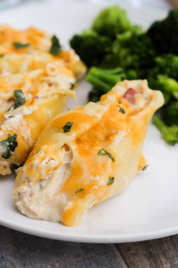 Chicken Bacon Ranch Stuffed Shells on a white plate with broccoli