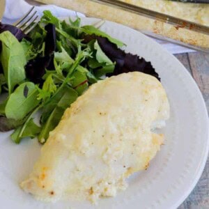 Baked Creamy Swiss Chicken on a plate with a salad