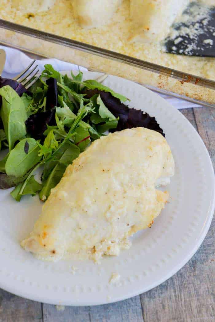 Baked Creamy Swiss Chicken on a plate with a salad