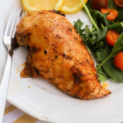 chicken marinade on a plate with salad and slice lemons