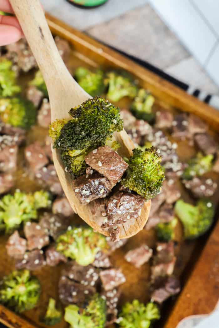 Sheet Pan Beef and Broccoli on a wooden spoon