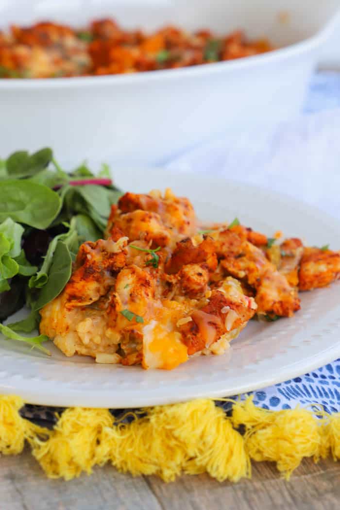 Chicken and Rice Queso Casserole on a white plate with green salad