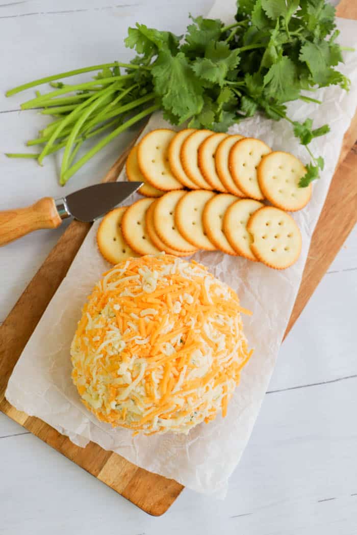 Pepper Jack Cheese Ball on a cutting board with crackers and cilantro
