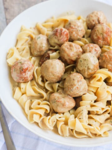 Slow Cooker Swedish Meatballs with noodles in white bowl