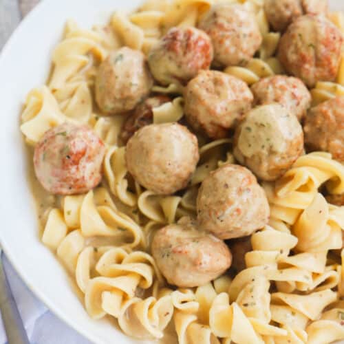 Slow Cooker Swedish Meatballs with noodles in white bowl