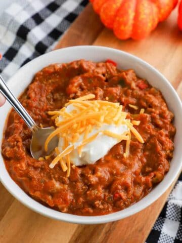 slow cooker pumpkin chili recipe in a bowl with spoon