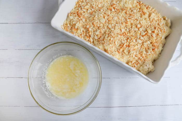melted butter in a clear bowl next to casserole in dish