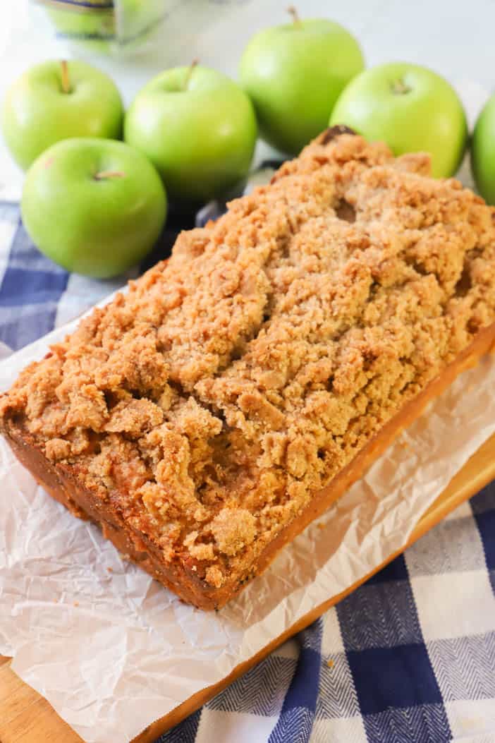 Dutch Apple Pie Bread on a wooden cutting board and apples