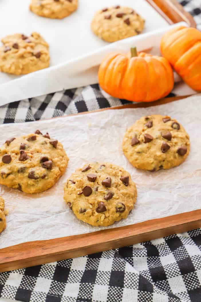 Pumpkin Oatmeal Chocolate Chip Cookie with pumpkins in the back