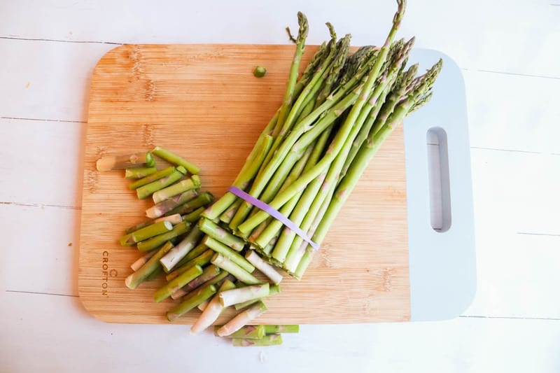 Asparagus with ends cut off on cutting board