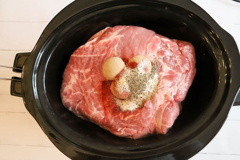 adding seasoning to the pork