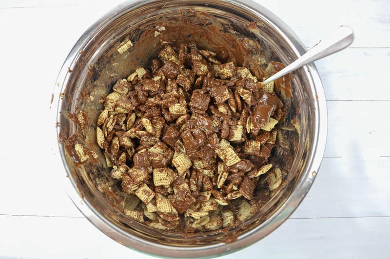 adding melted chocolate to the cereal