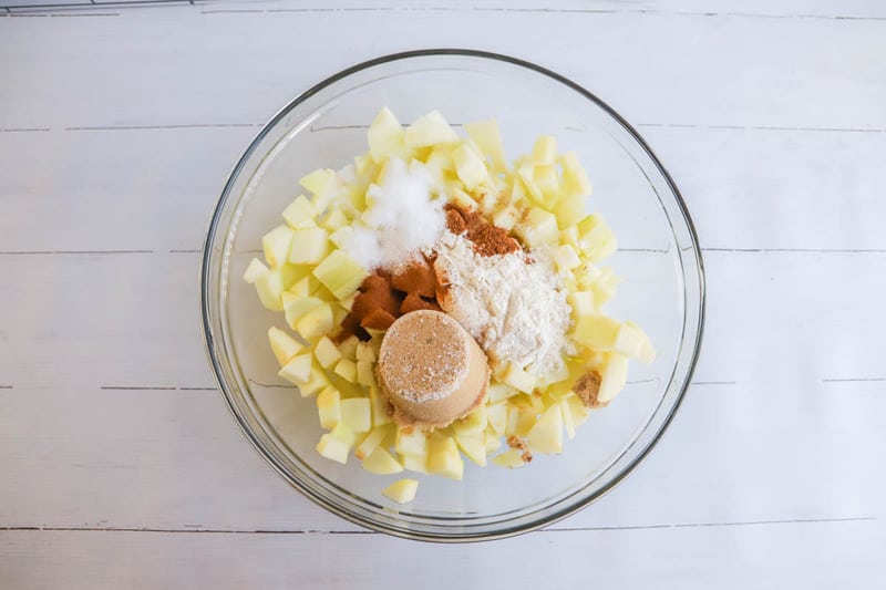 apples with spices and sugar in clear bowl