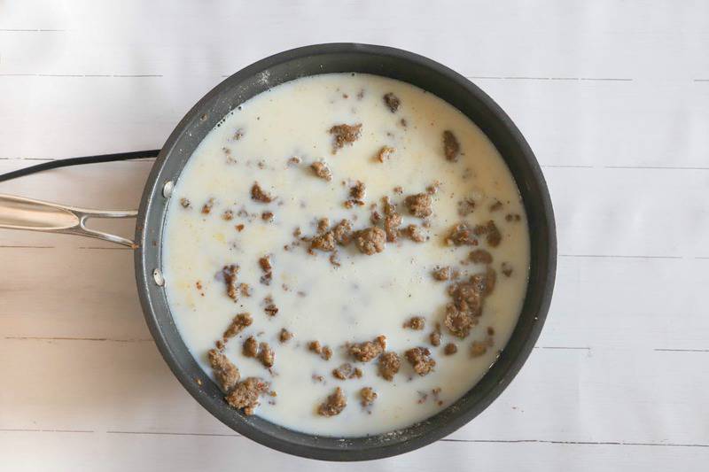adding milk to the sausage in a skillet