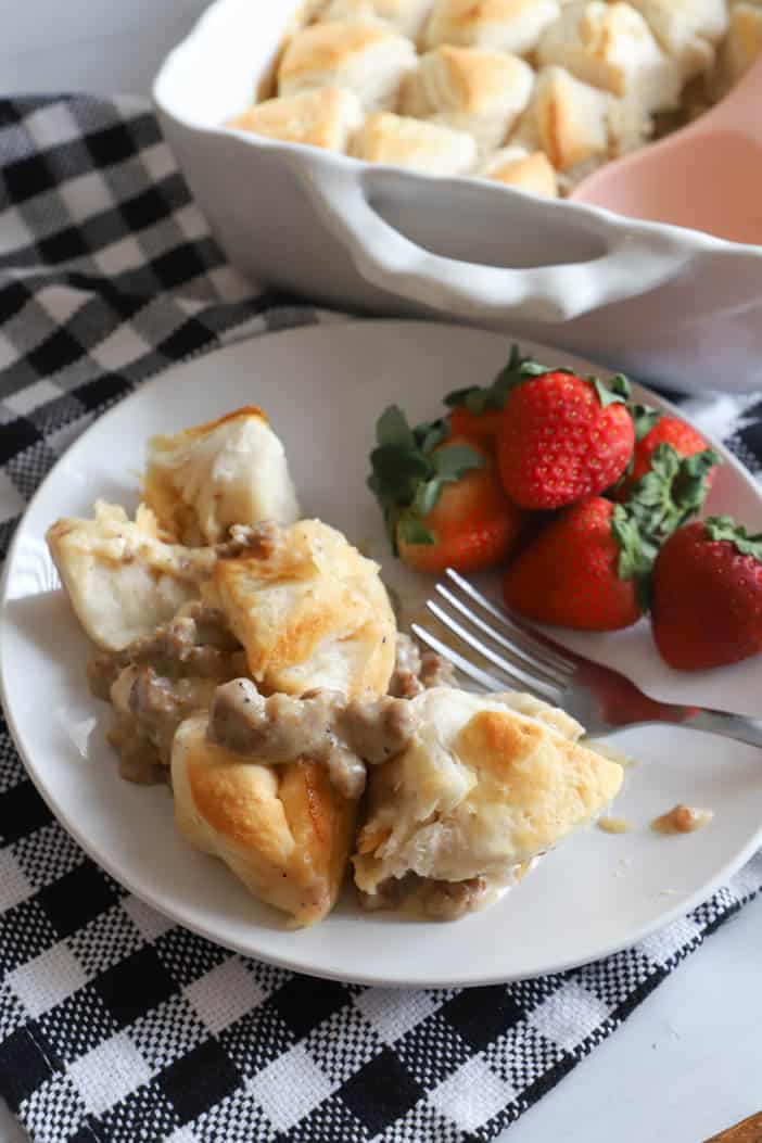 Biscuits and Gravy Casserole on a white plate with Strawberries