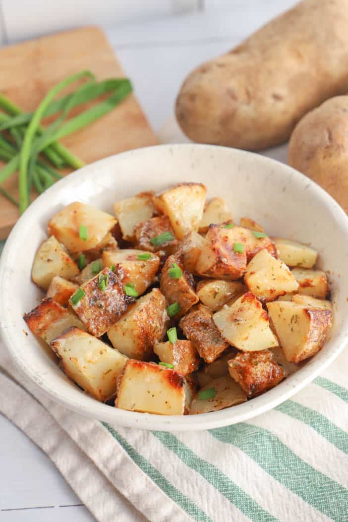 Air Fryer Ranch Potatoes in a white bowl with chives