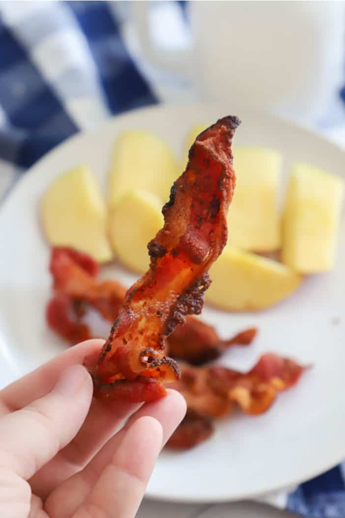 holding bacon in hand